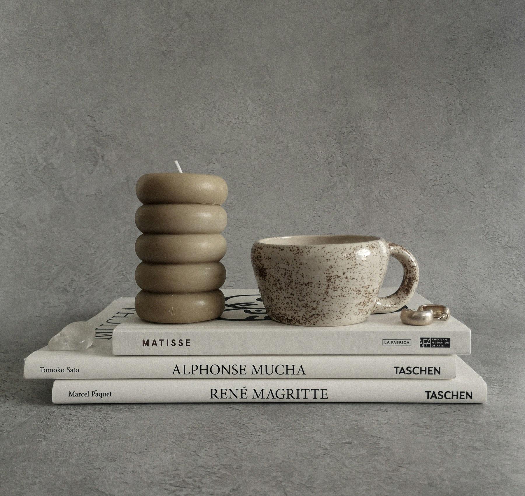 A candle, a mug and art books