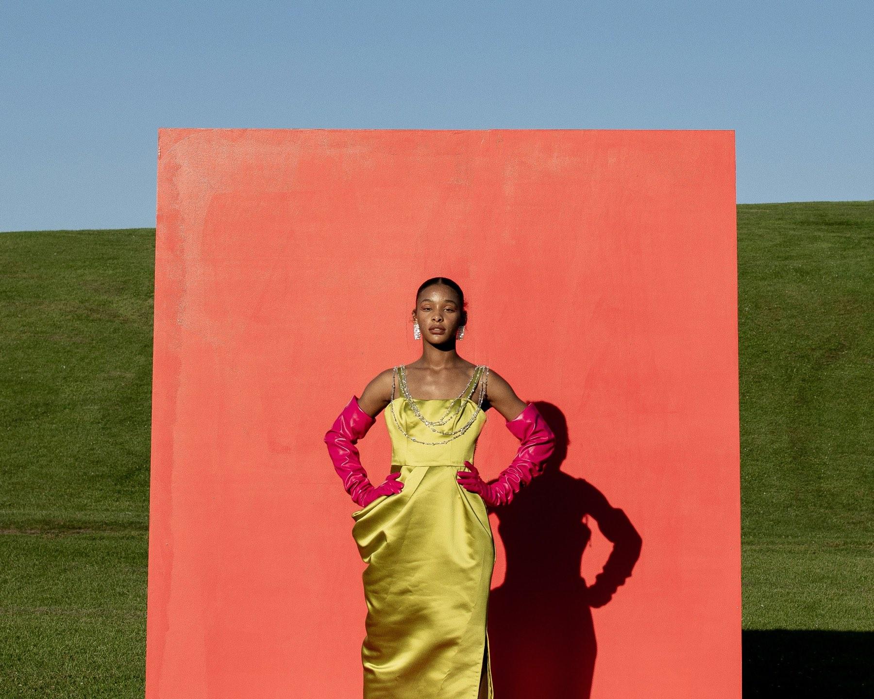 A yellow dress against an orange wall
